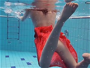 red clothed teenager swimming with her eyes opened